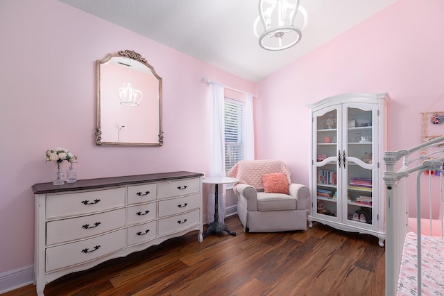 bedroom featuring a chandelier, lofted ceiling, and dark wood-type flooring