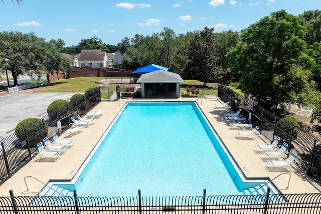 pool with a patio area and fence