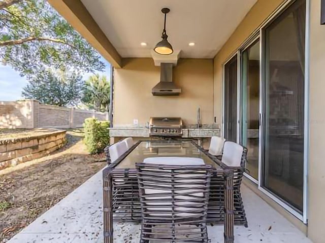 view of patio / terrace with fence, exterior kitchen, outdoor dining area, and area for grilling