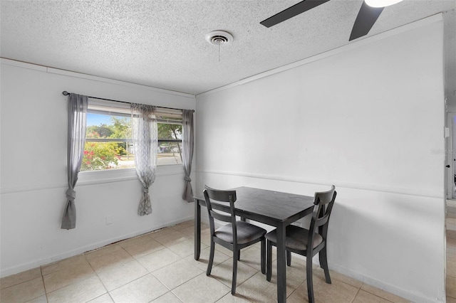 dining room featuring a textured ceiling, baseboards, visible vents, ceiling fan, and light tile patterned floors
