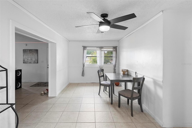 dining room featuring ceiling fan, a textured ceiling, ornamental molding, and light tile patterned flooring