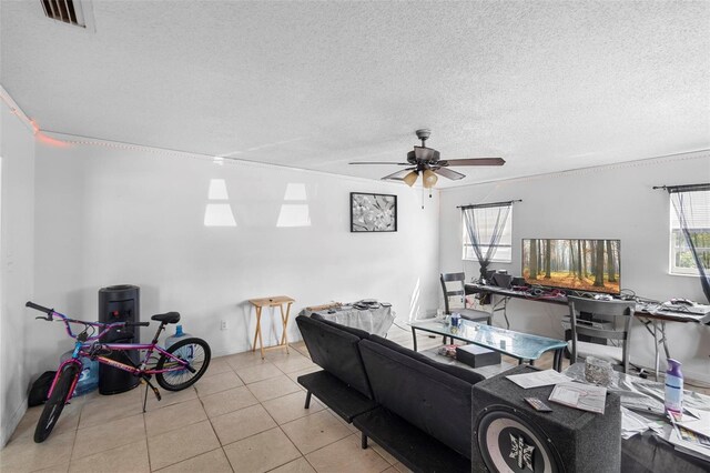 living room with ceiling fan, tile patterned floors, a textured ceiling, and visible vents