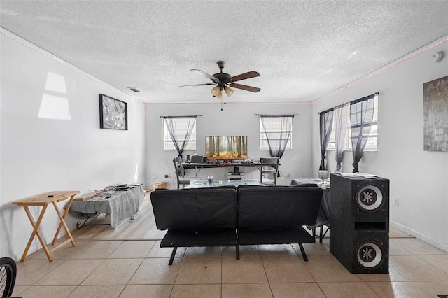 living room with crown molding, a ceiling fan, a textured ceiling, light tile patterned floors, and visible vents