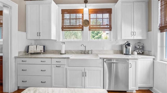 kitchen with a sink, white cabinets, and dishwasher