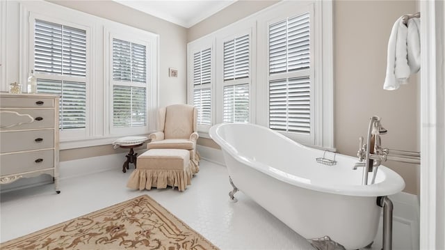 full bath with ornamental molding and a freestanding tub