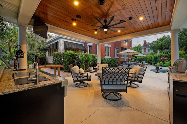 view of patio with a ceiling fan, outdoor dining space, a sink, an outdoor kitchen, and an outdoor hangout area