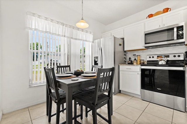 dining space with baseboards and light tile patterned flooring