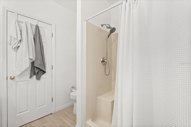bathroom featuring a shower with shower curtain and baseboards