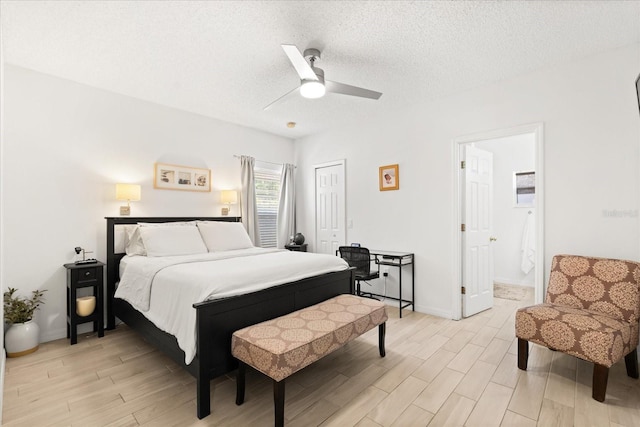 bedroom with ensuite bath, a closet, light wood-type flooring, a ceiling fan, and a textured ceiling