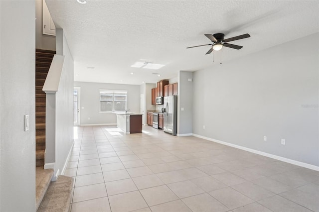 6013 Blue Lily Way, Winter Garden, FL 34787 - unfurnished living room with ceiling fan, stairs, a textured ceiling, and light tile patterned floors