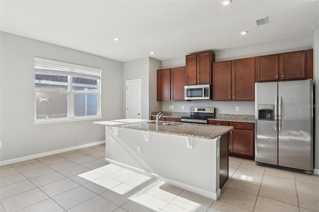 6013 Blue Lily Way, Winter Garden, FL 34787 - kitchen with stainless steel appliances, light stone countertops, a kitchen island with sink, light tile patterned floors, and recessed lighting