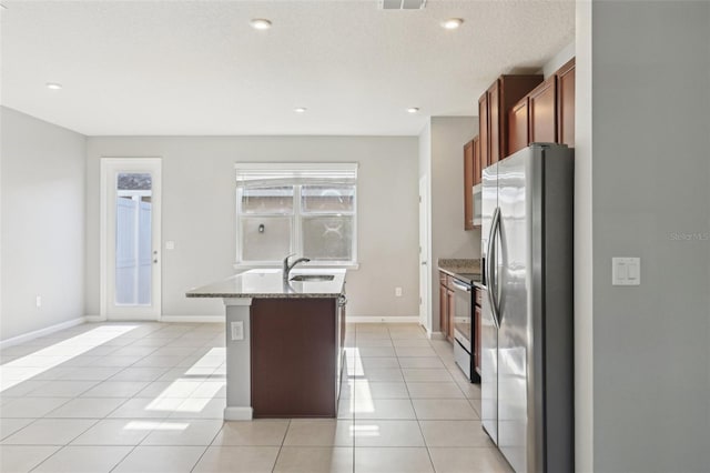 6013 Blue Lily Way, Winter Garden, FL 34787 - kitchen featuring appliances with stainless steel finishes, a center island with sink, light tile patterned floors, light stone counters, and recessed lighting