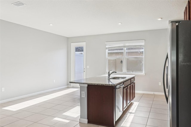 6013 Blue Lily Way, Winter Garden, FL 34787 - kitchen with stainless steel appliances, light tile patterned flooring, a kitchen island with sink, stone counters, and recessed lighting