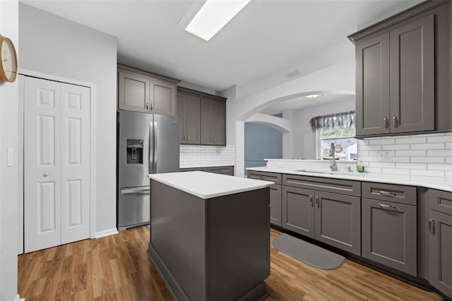 1868 Rachels Ridge Loop Unit L, Ocoee, FL 34761 - kitchen with stainless steel fridge with ice dispenser, arched walkways, light wood-style floors, and decorative backsplash