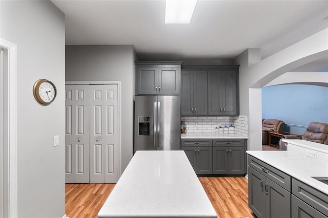 1868 Rachels Ridge Loop Unit L, Ocoee, FL 34761 - kitchen with stainless steel fridge, gray cabinetry, light wood finished floors, decorative backsplash, and arched walkways