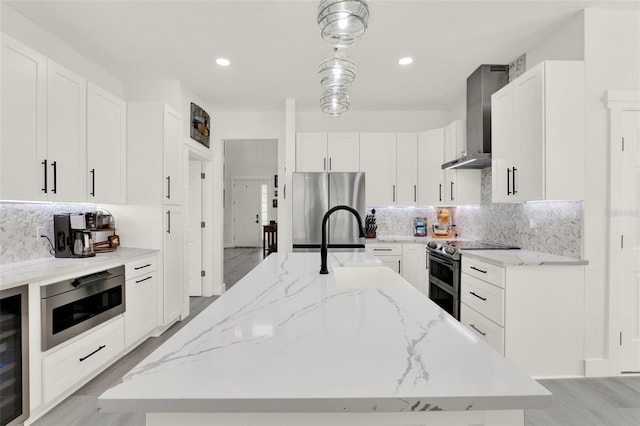 kitchen with wall chimney exhaust hood, stainless steel appliances, decorative backsplash, and light stone counters