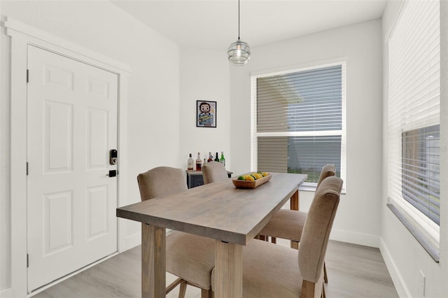 dining area featuring baseboards and light wood-style flooring