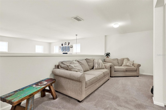carpeted living room with visible vents and baseboards