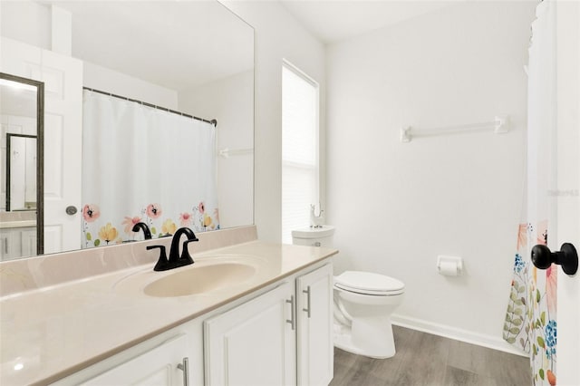 full bathroom with baseboards, toilet, vanity, and wood finished floors