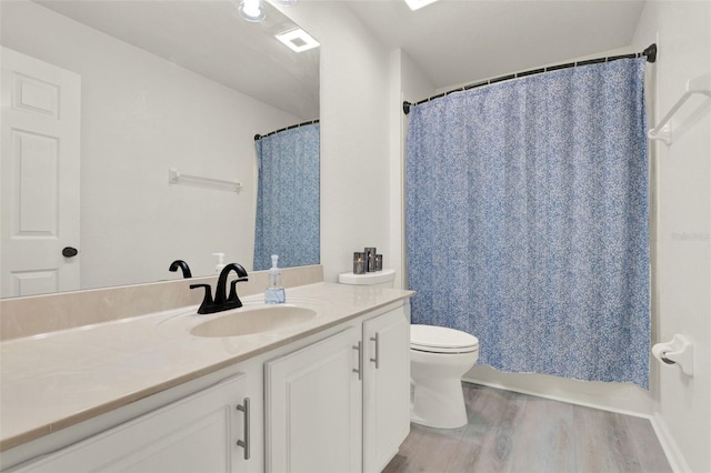bathroom featuring toilet, a shower with shower curtain, vanity, and wood finished floors