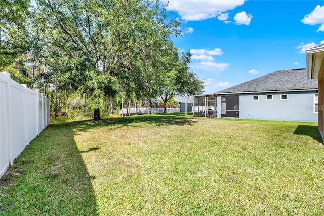 view of yard with a sunroom and a fenced backyard