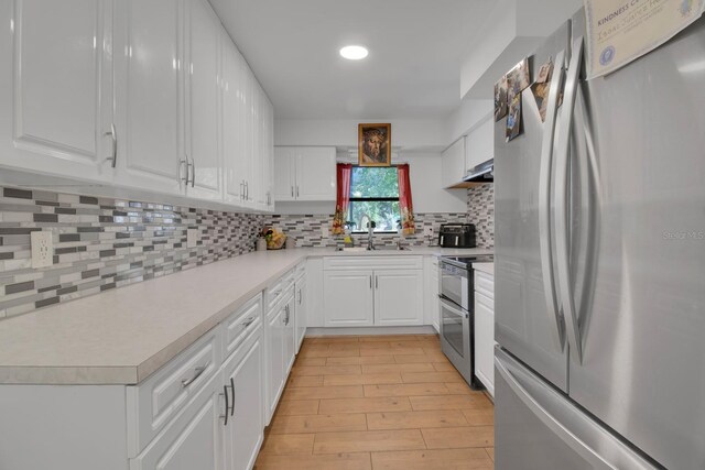 6464 Inca St, Orlando, FL 32807 - kitchen with appliances with stainless steel finishes, light countertops, white cabinets, tasteful backsplash, and recessed lighting