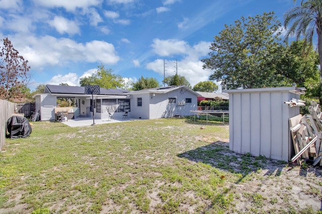 6464 Inca St, Orlando, FL 32807 - rear view of property featuring a shed, board and batten siding, a patio area, an outdoor structure, and roof mounted solar panels