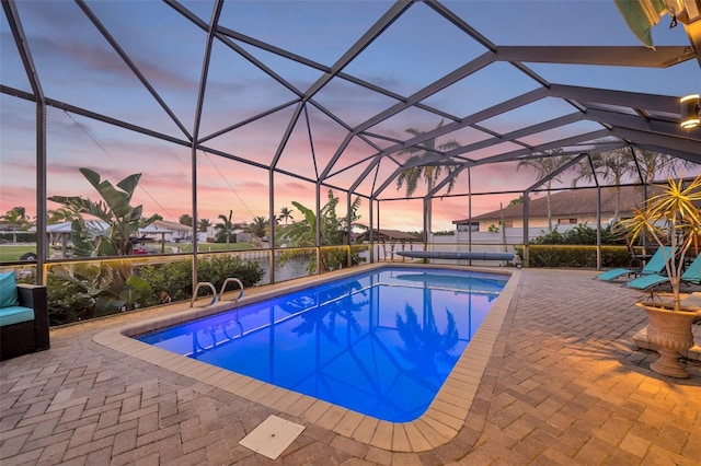 outdoor pool with a patio and glass enclosure