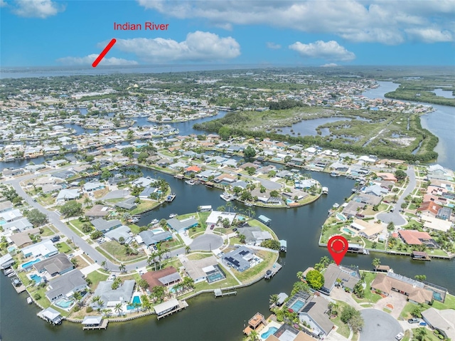aerial view of property's location with a nearby body of water and nearby suburban area