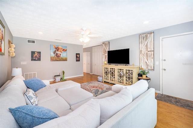 living area featuring visible vents, baseboards, recessed lighting, wood finished floors, and a ceiling fan