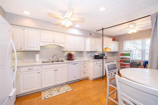 kitchen with a sink, ceiling fan, light wood-type flooring, white cabinetry, and white appliances