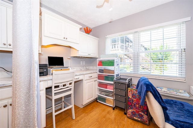 kitchen featuring light countertops, white cabinets, light wood-style flooring, and a healthy amount of sunlight