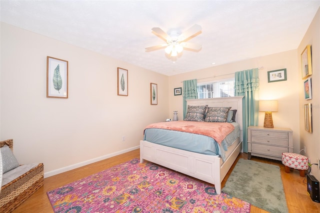 bedroom featuring ceiling fan, wood finished floors, and baseboards