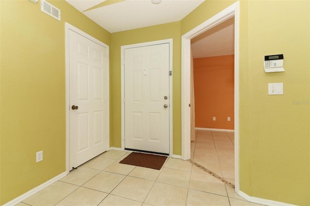 entrance foyer featuring light tile patterned floors, visible vents, and baseboards