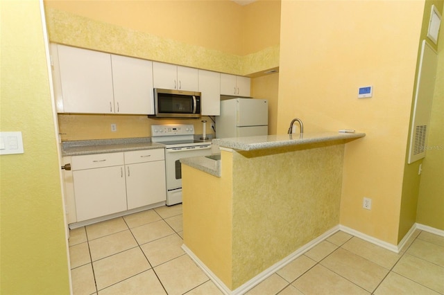 kitchen with white cabinetry, white appliances, a peninsula, and light tile patterned flooring