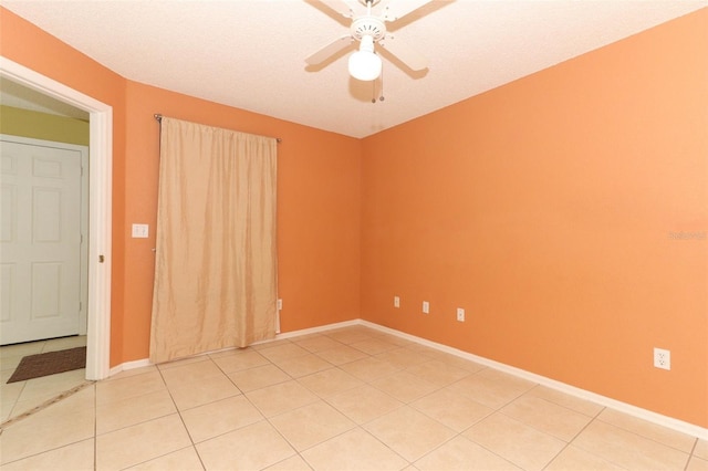 unfurnished room with baseboards, light tile patterned floors, and a ceiling fan