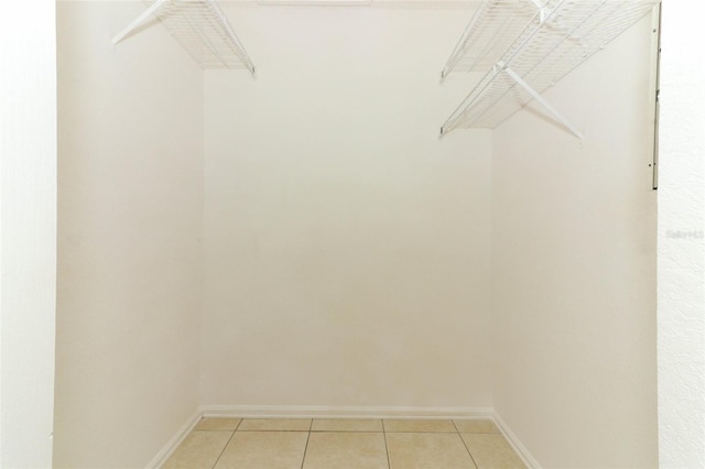 walk in closet with light tile patterned floors