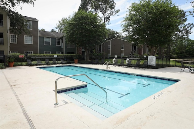 community pool with a patio and fence