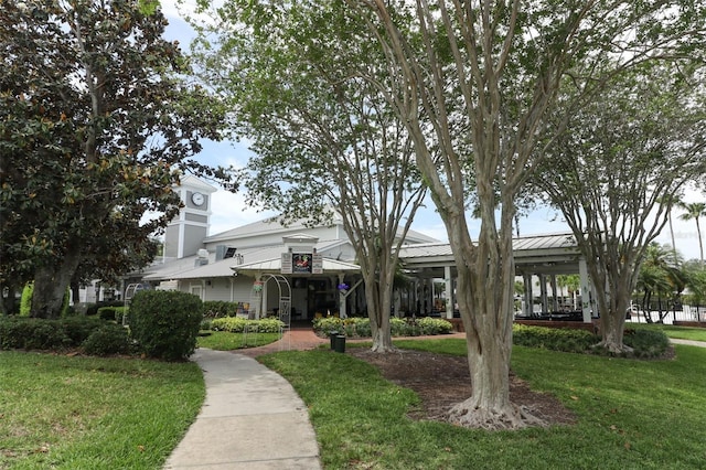 view of front of home with metal roof and a front lawn