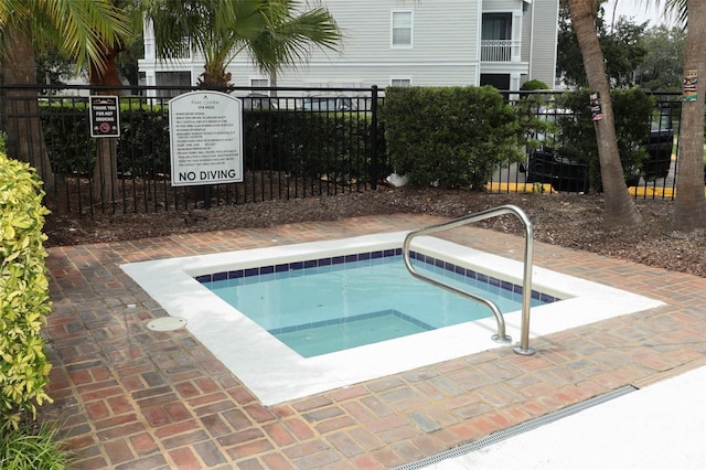 view of swimming pool with a community hot tub and fence