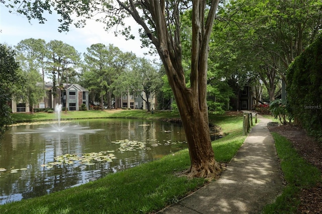 view of property's community featuring a lawn and a water view