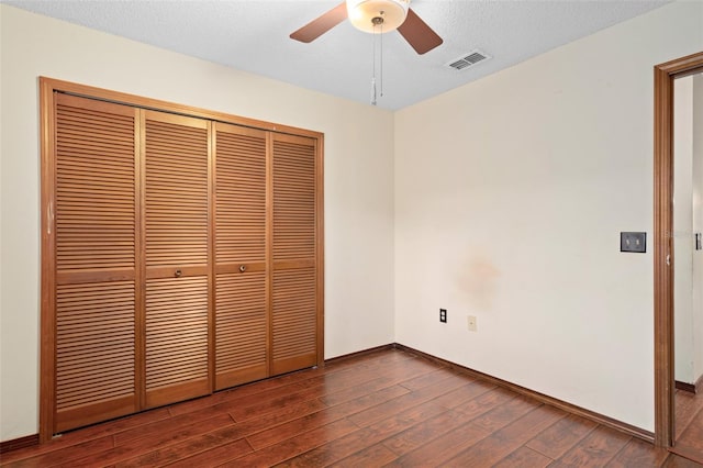 1105 Mill Run Cir, Apopka, FL 32703 - unfurnished bedroom featuring dark wood-type flooring, a closet, baseboards, a ceiling fan, and a textured ceiling