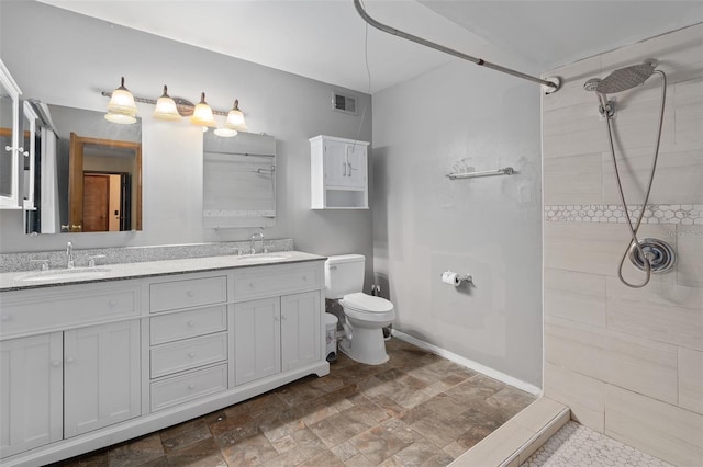1105 Mill Run Cir, Apopka, FL 32703 - bathroom with a tile shower, toilet, double vanity, and stone finish floors