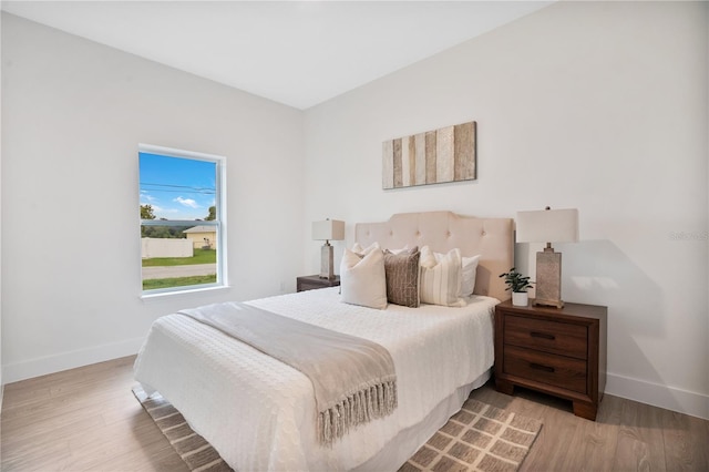 bedroom with light wood-style floors and baseboards