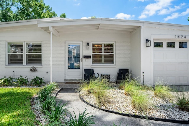 1424 W New Hampshire St, Orlando, FL 32804 - view of exterior entry with brick siding and an attached garage