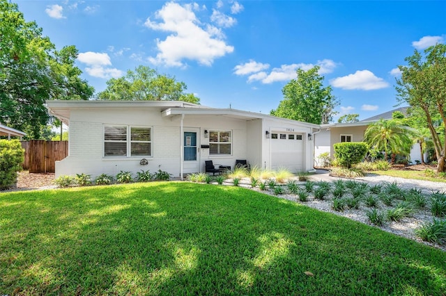 1424 W New Hampshire St, Orlando, FL 32804 - view of front facade with fence, a front lawn, brick siding, a garage, and driveway