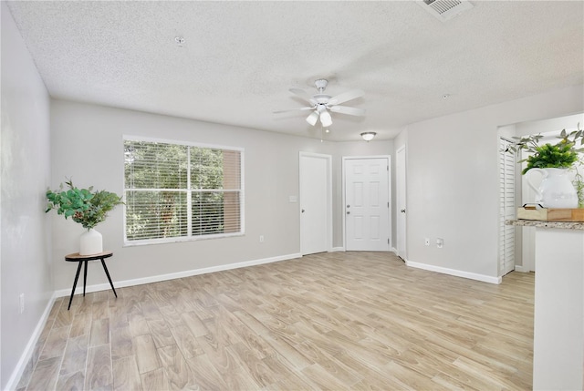 956 Salt Pond Pl Unit 207, Altamonte Springs, FL 32714 - unfurnished living room featuring a ceiling fan, a textured ceiling, light wood-style floors, and baseboards