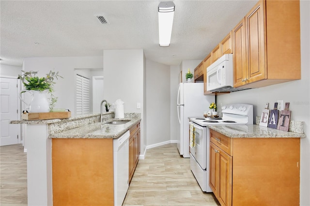 956 Salt Pond Pl Unit 207, Altamonte Springs, FL 32714 - kitchen featuring white appliances, a peninsula, a sink, a textured ceiling, and light stone counters