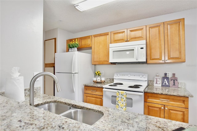 956 Salt Pond Pl Unit 207, Altamonte Springs, FL 32714 - kitchen with white appliances, a sink, light stone countertops, a textured ceiling, and brown cabinets