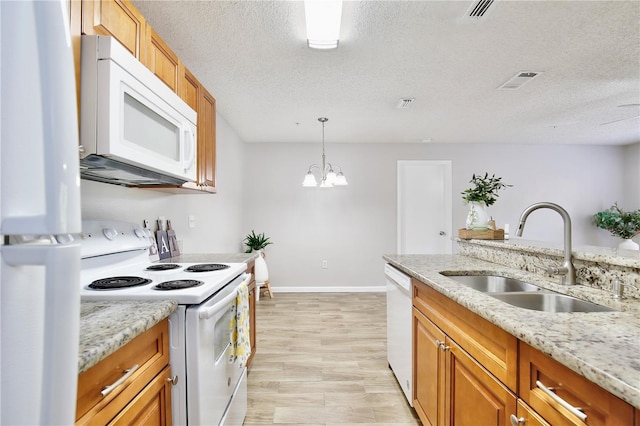 956 Salt Pond Pl Unit 207, Altamonte Springs, FL 32714 - kitchen with white appliances, a sink, a textured ceiling, baseboards, and brown cabinets